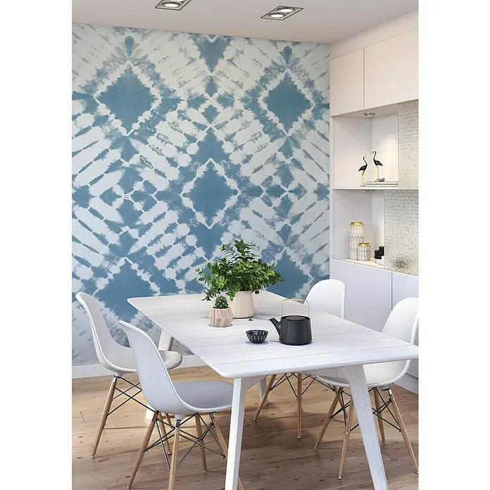 Rasch Beachhouse Fototapete Batikoptik II - B x H: 300 x 265 cm, Vlies, Blau - Stilvolles Esszimmer mit Esstisch, Stühlen, Pflanzen und einem Teekessel, vor einer blauen Akzentwand.