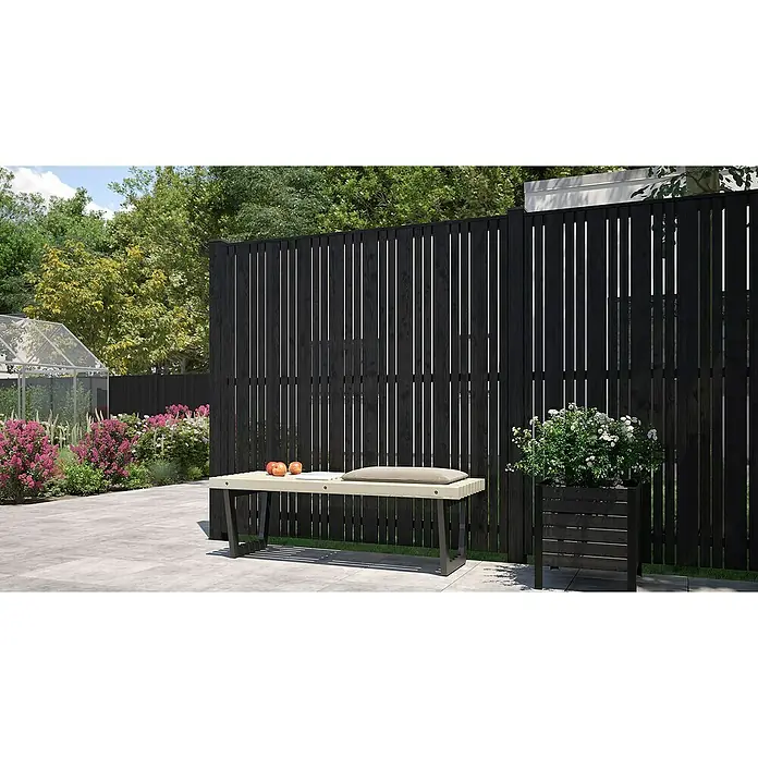 Plus Pfostenkappe Classic - 9,1 x 9,1 cm - Eine moderne Gartenszene mit einem schwarzen Holzzaun, einer hellen Bank mit Kissen und einem passenden Pflanzgefäß.
