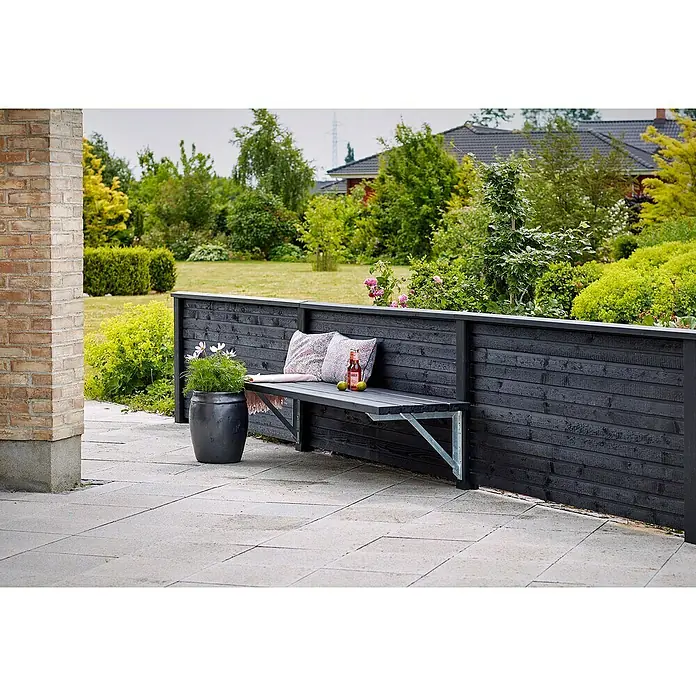 Plus Sichtschutzelement Plank - 174 x 91 cm, Schwarz (RAL 9005) - Gartenbank aus dunklem Holz mit Kissen und Getränk.