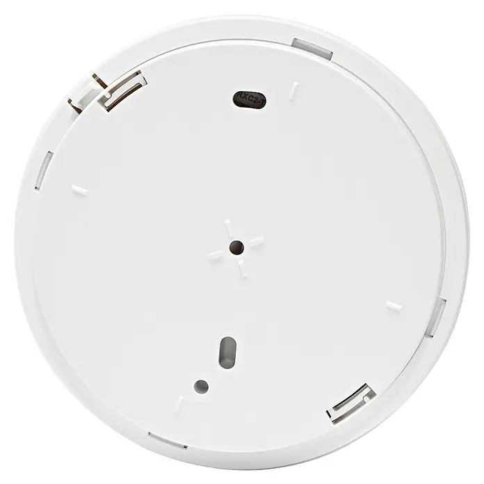 Homematic IP Rauchwarnmelder mit Q-Label - Durchmesser: 11,5 cm, Batterielaufzeit: 10 Jahre, Alarmsignal: 85 dB - Ansicht der Unterseite eines runden, weißen Geräts mit Schlitzen und Befestigungslöchern.