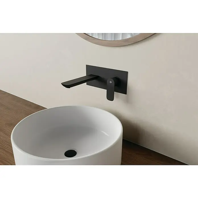 IO Cassio Grifo de lavabo Cassio - Negro - Primer plano de un baño moderno con un elegante grifo negro de pared y un lavabo redondo y elegante.