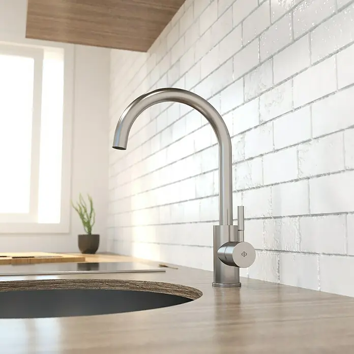 IO Round Grifo de cocina - Acero, Satinado - Primer plano de un moderno grifo de cocina de acero inoxidable sobre una encimera de madera frente a un protector contra salpicaduras de azulejos blancos.