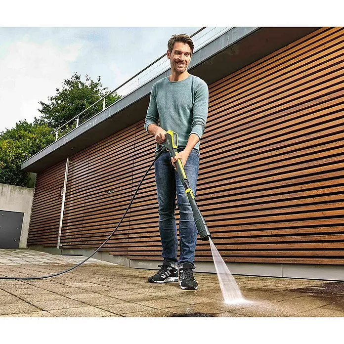 Kärcher Hidrolimpiadora de alta presión K7 Premium Smart Control Flex - 180 bar, 3.000 W, Capacidad de bombeo: 600 l/h, 5 pzs. - Un hombre usa una hidrolavadora Kärcher para la limpieza. El Kärcher elimina la suciedad del patio a alta presión.