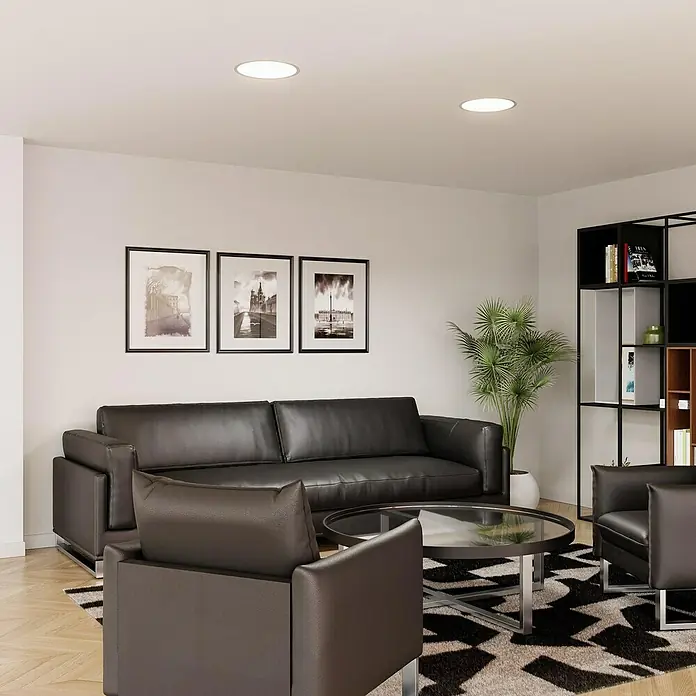 Alverlamp Downlight empotrable LED redondo - 30 W, Ø x Al: 29,5 x 1,5 cm, Negro, Blanco cálido - Sala de estar con sofá de cuero negro, sillones y mesa de centro sobre una alfombra geométrica. Las luces de techo brillantes realzan el ambiente.