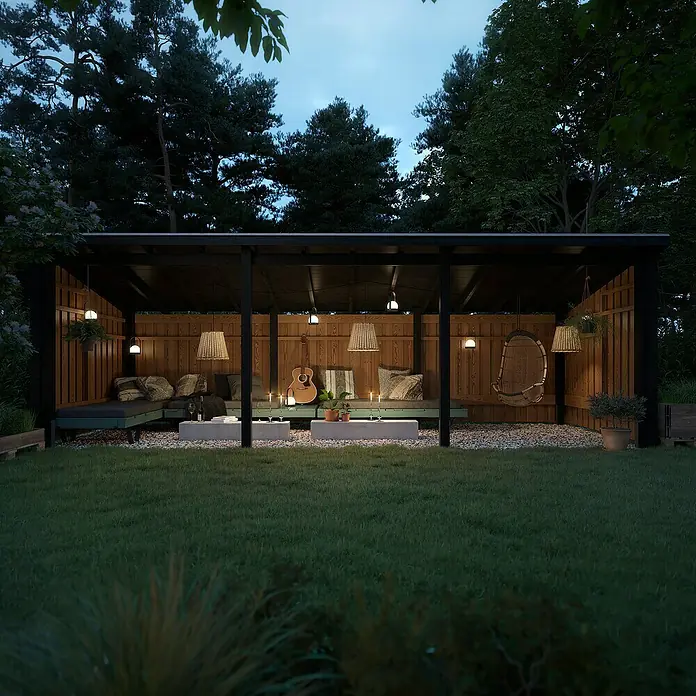Plus Gartenhaus Multi Nordic - Außenmaß inkl. Dachüberstand (B x T): 650 x 240 cm, Holz, Offen inkl. H-Pfostenanker, Dachpappe und Aluleisten - Ein gemütlicher Outdoor-Pavillon aus Holz mit dunklen Sitzkissen, Betontischen und stimmungsvoller Beleuchtung auf Kies in einem Garten bei Dämmerung.