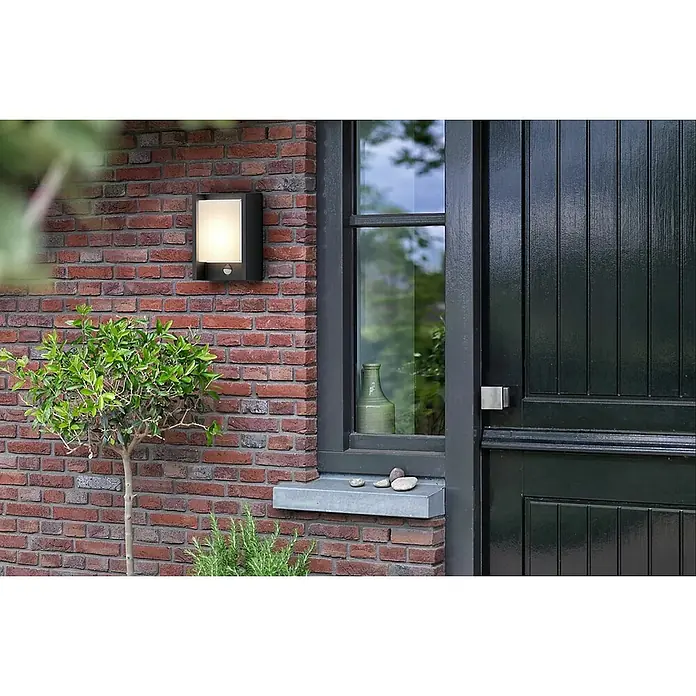 Philips Arbour LED-Sensor-Außenwandleuchte - 3,8 W, 16,5 x 7,5 x 22 cm, IP44 - Außenansicht eines modernen Hauses mit einer stilvollen Außenleuchte an der Backsteinmauer neben Fenster und Tür.