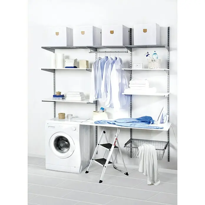 Phönix Wandregal-Set Staxx Diele - L x B x H: 47 x 66 x 223 cm, Traglast Einlegeboden: 20 kg, Weiß/Grau - Ein heller Wäscheraum mit einer Waschmaschine, Regalen, weißen Kartons, einer Leiter und einem Bügelbrett für die Wäschepflege.