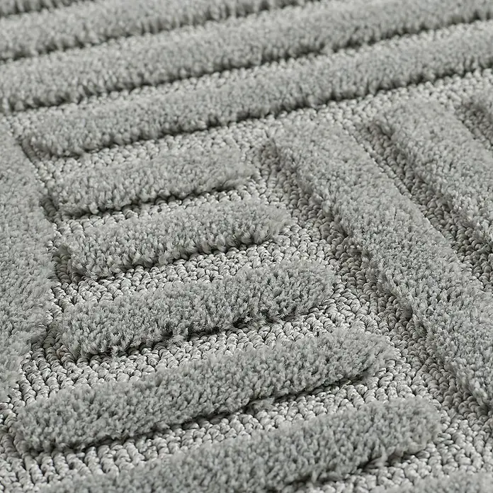 Kurzflorteppich Art - Silber, 290 x 200 cm, 100 % Polypropylen - Detailaufnahme einer grauen Badematte mit geometrischem Muster. Die weiche Textur lädt zum Verweilen ein und sorgt für Komfort im Badezimmer.