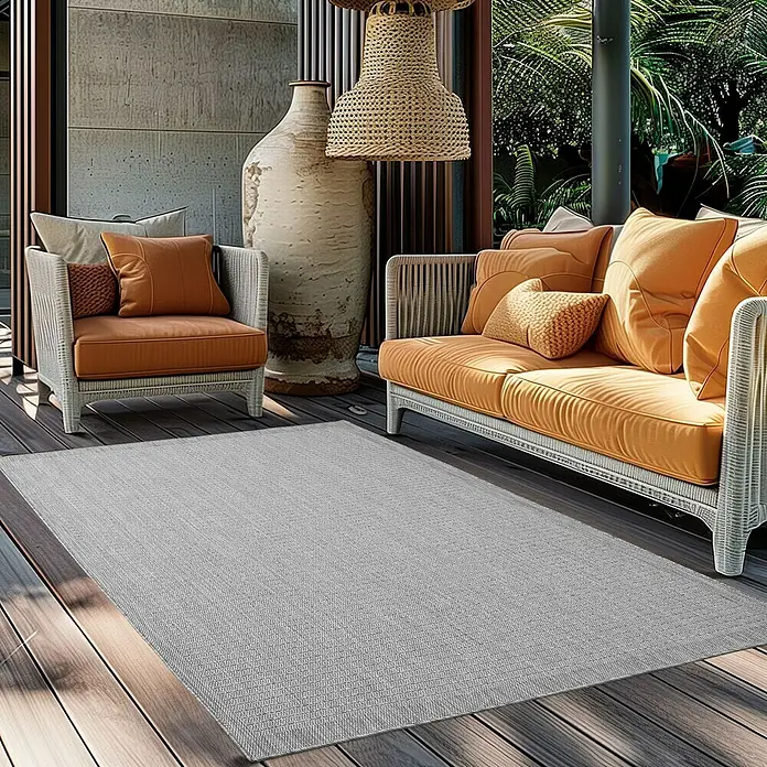 Outdoor-Teppich Giza 1410 - Grau, 340 x 240 cm, 100 % Polypropylen - Ein grauer Outdoor-Teppich liegt auf einer Terrasse mit Möbeln. Der Teppich ist dezent und passt gut zum Außenbereich.