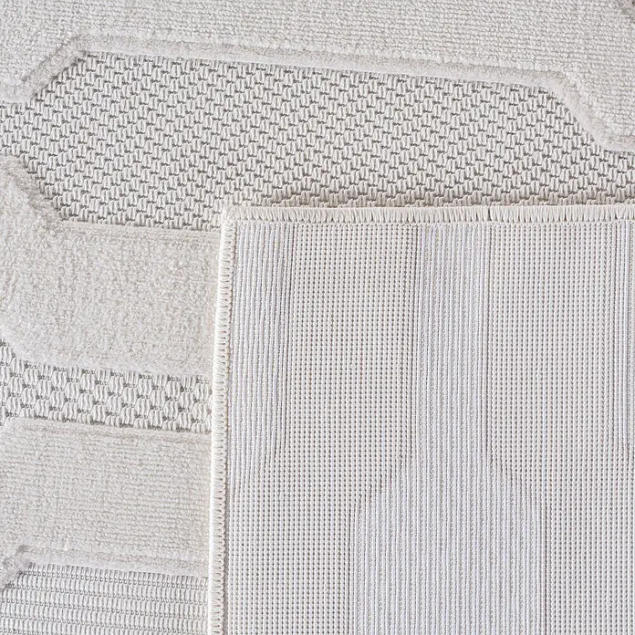 Kurzflorteppich Doha 1654 - Creme, 340 x 240 cm, 100 % Polypropylen - Nahaufnahme eines cremefarbenen Teppichs mit geometrischen Mustern und einer rutschfesten Rückseite für zusätzlichen Halt.