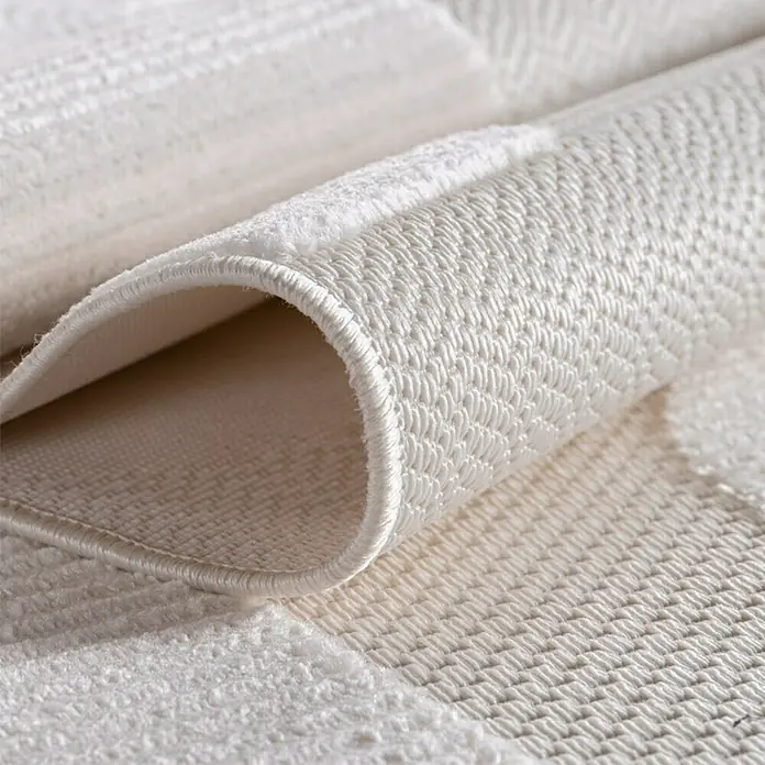 Kurzflorteppich Doha 1651 - Creme, 150 x 80 cm, 100 % Polypropylen - Detailaufnahme eines weißen Teppichs mit gewebter Textur und gerolltem Rand, der die hochwertige Verarbeitung und das Design hervorhebt.