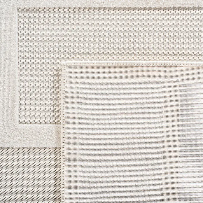 Kurzflorteppich Doha 1657Creme, 290 x 200 cm, 100 % Polypropylen - Nahaufnahme eines hellen Teppichs mit detailliertem Webmuster und einer schlichten Bordüre. Ein stilvolles und dekoratives Element für Ihr Zuhause.