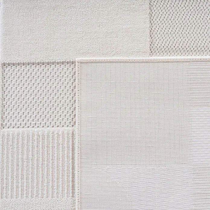 Kurzflorteppich Doha 1651 - Creme, 150 x 80 cm, 100 % Polypropylen - Nahaufnahme eines hellen Teppichs mit verschiedenen Texturen und einer detaillierten Verarbeitung, die Qualität und Komfort ausstrahlt.