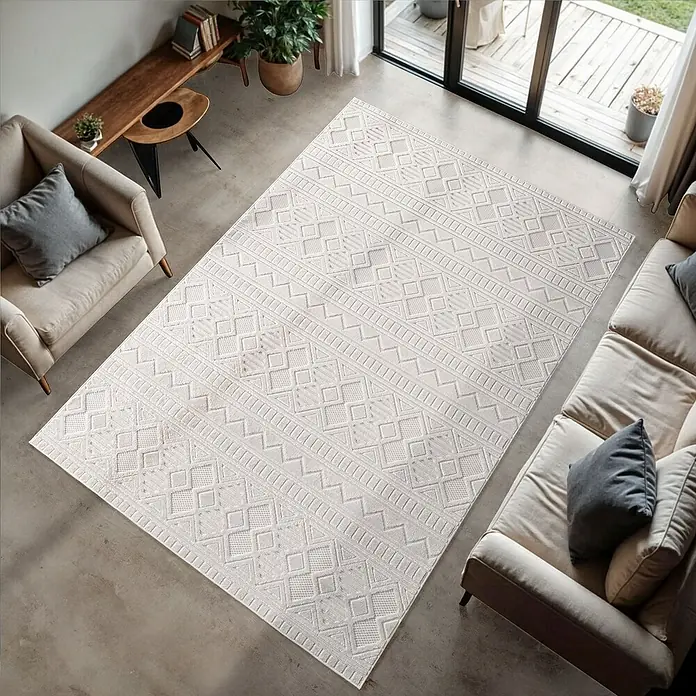 Kurzflorteppich Doha 1652 - Creme, 170 x 120 cm, 100 % Polypropylen - Wohnzimmeransicht von oben mit beigem Sofa und Sessel, stilvollem Teppich mit geometrischem Muster und Holzboden.