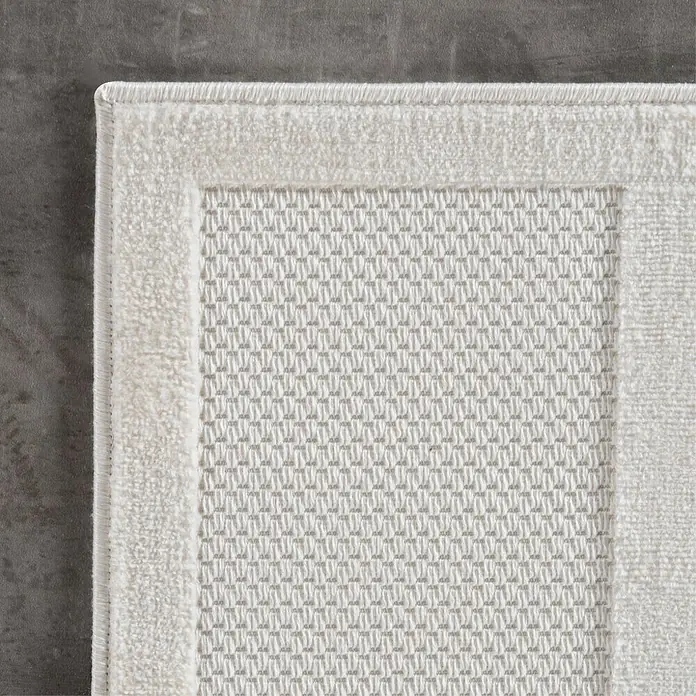 Kurzflorteppich Doha 1657Creme, 290 x 200 cm, 100 % Polypropylen - Detailansicht einer weißen Badematte mit strukturierter Oberfläche und weichem Rand.