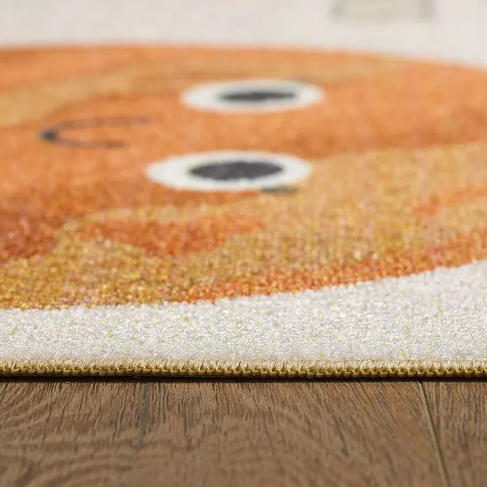 Kinderteppich Play 2019 - Beige, 150 x 100 cm, 100 % Polypropylen - Nahaufnahme eines farbenfrohen Teppichs mit Tiermotiv auf einem Holzboden, der die Textur und das Design des Teppichs hervorhebt.