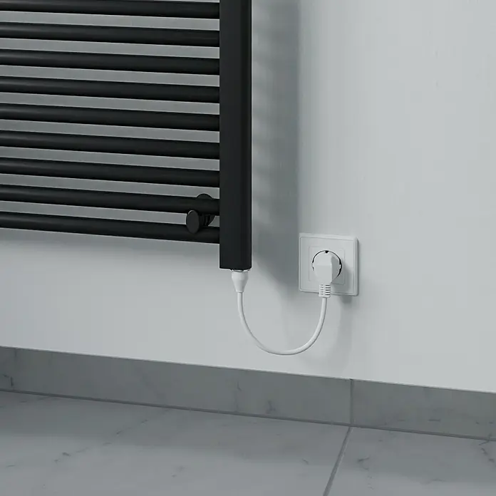 Elektro-Badheizkörper Kitty - B x H: 600 x 1.200 mm, Nennleistung: 600 W, Schwarz - Ein dunkler Handtuchwärmer ist an der Wand montiert und mit einem weißen Stecker verbunden. Das Gerät dient zum Trocknen und Wärmen von Handtüchern.