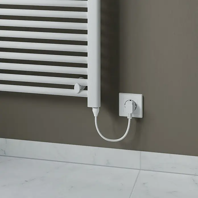Elektro-Badheizkörper Kitty - B x H: 600 x 1.200 mm, Nennleistung: 600 W, Weiß - Nahaufnahme einer weißen Handtuchheizung mit Stecker in der Steckdose, montiert an einer grauen Wand über einem weißen gefliesten Boden.