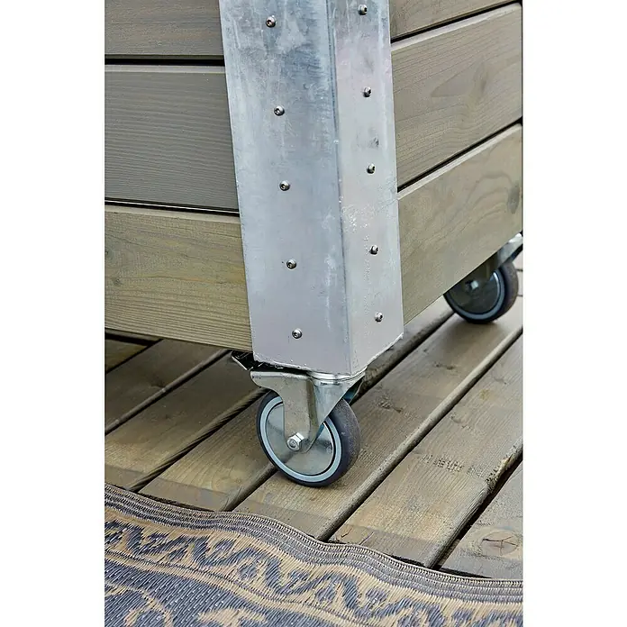 Plus Pflanzkasten Cubic - Außenmaß (L x B x H): 120 x 50 x 95 cm, Holz, Grau/Braun - Grauer Holzbehälter auf Rollen mit glänzenden Metalleckstützen, auf einer Holzterrasse.