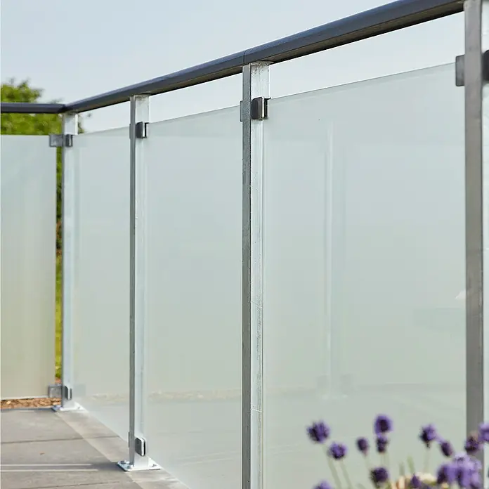 Plus Sichtschutzzaun für quadratische Pfosten - 90 x 91 cm, Matt satiniert, 8,7 mm - Nahaufnahme einer modernen Glasbalustrade mit Metallrahmen und Befestigungen auf einer Terrasse im Freien.