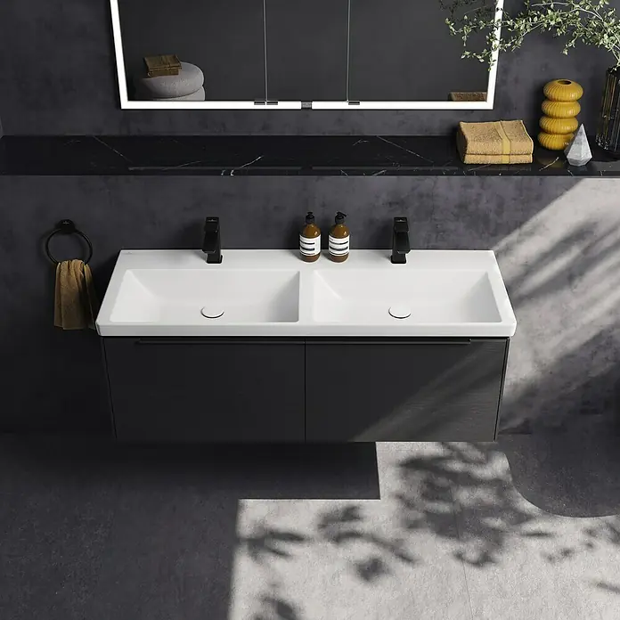 Villeroy & Boch Subway 3.0 Aufsatzwaschbecken - Ohne Spezialglasur, Ohne Überlauf, Weiß Alpin, Höhe: 16,5 cm, Anzahl Hahnlöcher: 2 - Ein modernes Badezimmer mit einem doppelten weißen Waschtisch, zwei schwarzen Armaturen und einem wandmontierten Waschtischunterschrank in dunkler Holzoptik.