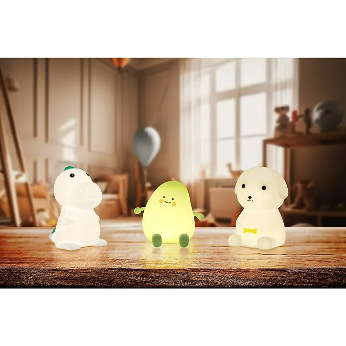 FHL easy LED-Nachtlicht Leo - 0,6 W, L x B x H: 9 x 10 x 13,5 cm, RGBW, Welpe Leo - Drei leuchtende Nachtlichter (Dinosaurier, Avocado, Hund) auf einem Holztisch in einem Kinderzimmer.