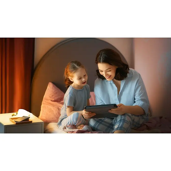 FHL easy LED-Nachtlicht Lesley - 0,9 W, L x B x H: 21 x 10,3 x 6,2 cm, Warmweiß, Ente Lesley - Mutter und Kind im Bett schauen gemeinsam freudig auf ein Tablet.