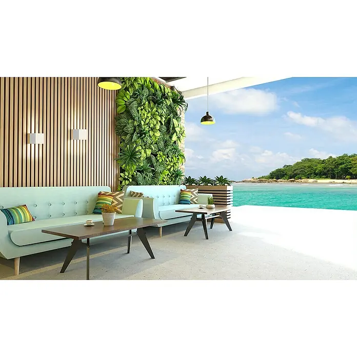 FHL easy Akku-Wandleuchte - 5,5 x 10 x 10 cm, Sandweiß, Warmweiß, 2 W, IP44 - Eine moderne Außenterrasse mit hellblauen Sofas, Holzlamellenwänden, einem vertikalen Garten und Couchtischen mit Blick auf einen tropischen Strand.