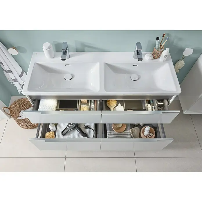 Villeroy & Boch Subway 3.0 Aufsatzwaschbecken - Mit schmutzabweisender Glasur, Mit Überlauf, Stone White, Anzahl Hahnlöcher: 2, Anzahl Waschschüsseln: 2 Stk. - Weißer Doppelwaschtisch mit zwei integrierten Becken und Auszügen, die organisiertes Badzubehör zeigen.