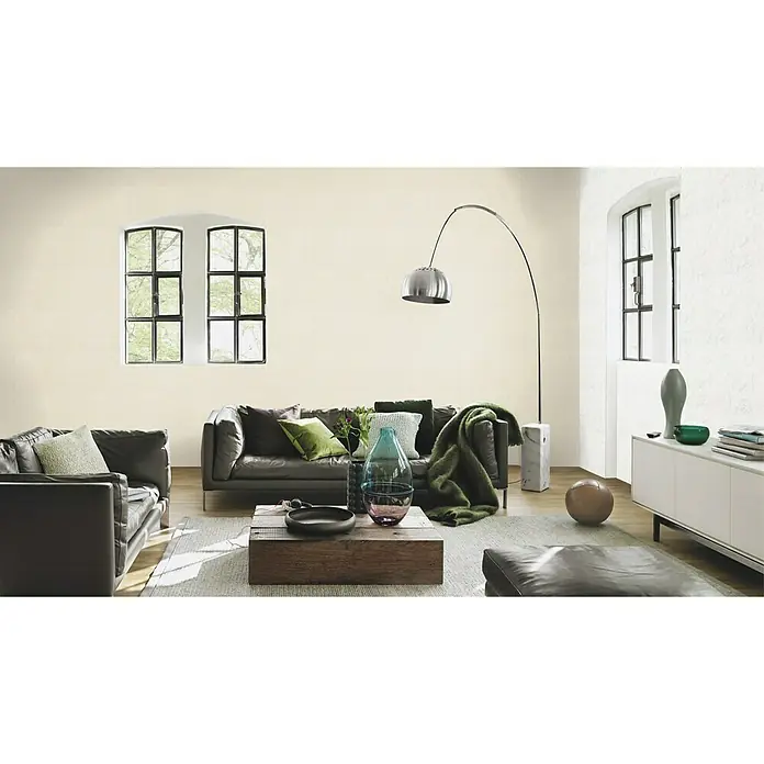 Rasch Vliestapete Putzstruktur - Creme, Uni, 10,05 x 0,53 m, Spachtelstruktur - Wohnzimmer mit braunen Ledermöbeln, einem Couchtisch aus Holz und einem silbernen Bogenlampe, die eine gemütliche und stilvolle Atmosphäre schafft.
