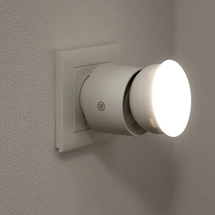LED-Steckdosenspot - Ø x H: 6,3 x 10,4 cm, Weiß, 10 W, 1.000 lm, Dimmbar - Nahaufnahme eines LED-Nachtlichts, das in eine Steckdose gesteckt ist und ein sanftes, helles Licht ausstrahlt.