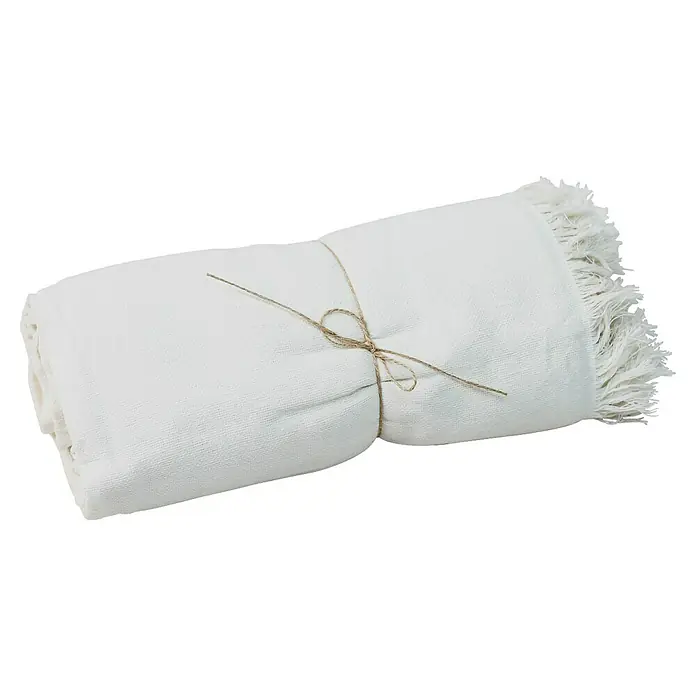 Manta para sofá Multiusos XXL - Textil, Natural - Una toalla blanca con flecos, enrollada y atada con un cordel, exhibe su textura suave y detalle decorativo para un toque acogedor.