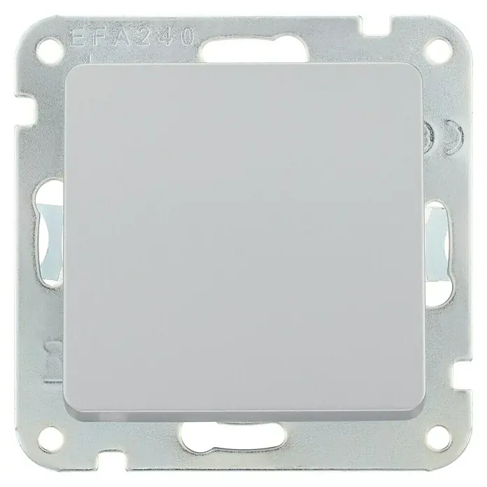 Luceco Oxford Tapa ciega - Plata, Plástico, Montaje en la pared - Primer plano de un interruptor de luz gris cuadrado con marco metálico, sobre una superficie blanca.