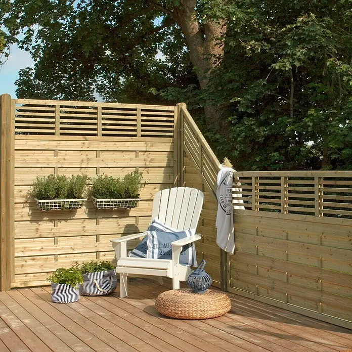 Plus Sichtschutzelement Newline - 180 x 110 cm, Natur - Entspannende Gartenszene mit Holzzaun, weißem Stuhl, Sitzkissen und Pflanzgefäßen auf einer hölzernen Terrasse mit üppigem Grün im Hintergrund.