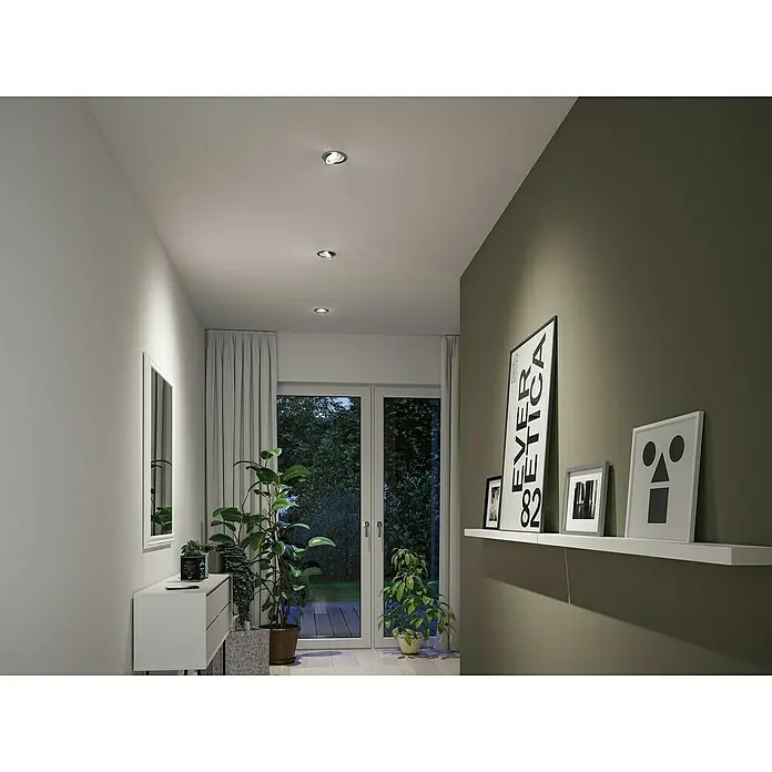 Paulmann LED-Einbauspot - Warmweiß, Durchmesser: 10,5 cm, Chrom matt, 3 Stk. - Eine moderne Innenaufnahme mit Deckenspots, die ein gemütliches Licht in einem Flur mit Pflanzen und dekorativen Elementen erzeugen.