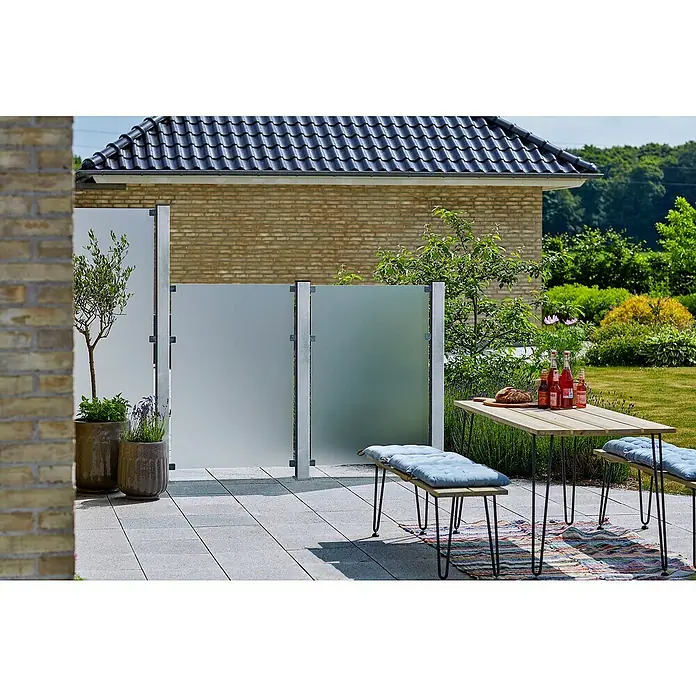 Plus Zaunpfosten mit Fuß und Schrauben-Set - Höhe: 132 cm, 8 x 8 cm, Silber, Stahl - Eine Terrasse mit einer modernen Sichtschutzwand, einem Holztisch mit Bänken und Pflanzen in Töpfen, die eine gemütliche Atmosphäre schaffen.