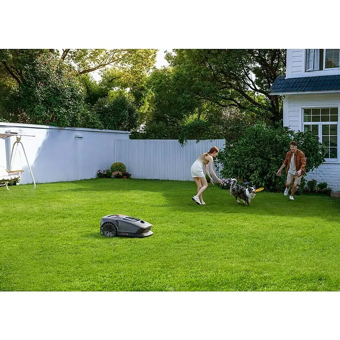 Mova Mähroboter 600 Plus - 600 m², Schnittbreite: 20 cm, Laser-gestützte Navigation, LiDAR - Ein Rasenmähroboter auf einem grünen Rasen, während Menschen und ein Hund im Hintergrund spielen.
