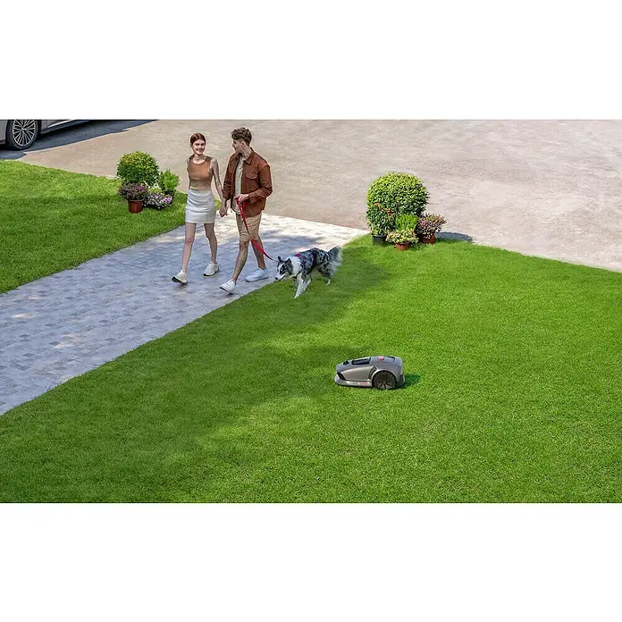 Mova Mähroboter 600 Plus - 600 m², Schnittbreite: 20 cm, Laser-gestützte Navigation, LiDAR - Ein Rasenmähroboter mäht den Rasen, während ein Paar mit einem Hund spazieren geht. Der Mähroboter ist grau und hat schwarze Räder.