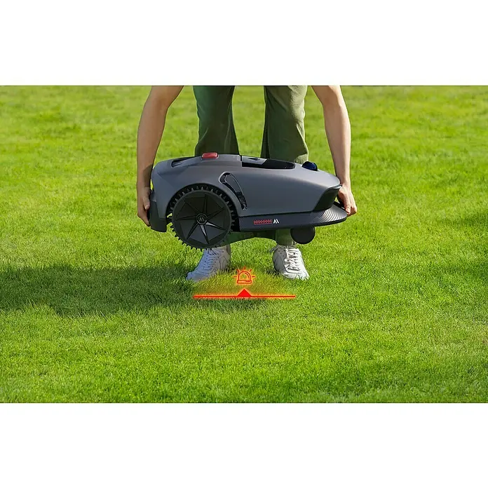 Mova Mähroboter 600 Plus - 600 m², Schnittbreite: 20 cm, Laser-gestützte Navigation, LiDAR - Eine Person trägt einen grauen Mähroboter über einem grünen Rasen, der für die Rasenpflege im Garten konzipiert ist.