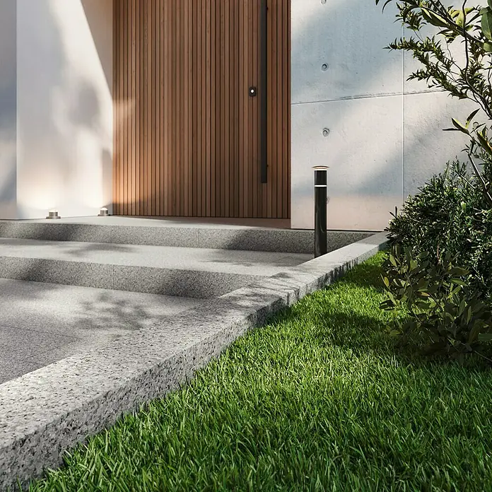 Palisade G 603 - 100 x 12 x 12 cm, Grau - Ein elegant gestalteter Außenbereich mit einem modernen Strahler neben einer Treppe und üppigem Grün.