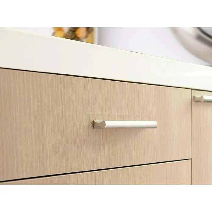 Rei Tirador para muebles 2279 - Distancia entre orificios: 128 mm, Anodizado, Mate, 4 ud. - Primer plano de cajones de madera con tiradores plateados y una encimera clara en una cocina.