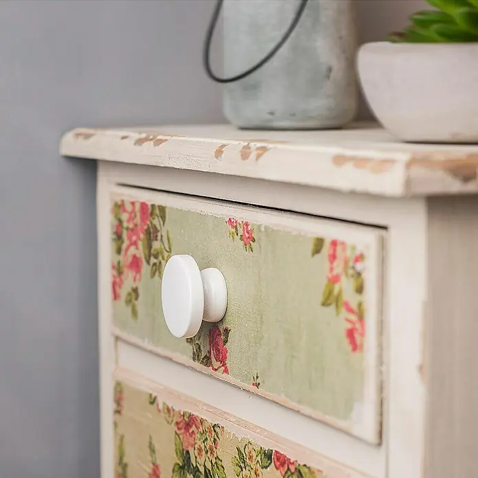 Rei Pomo para muebles Haya - Diámetro: 38 mm, Blanco, 6 ud. - Primer plano de una cómoda con estampado floral y tirador blanco, estilo shabby chic.