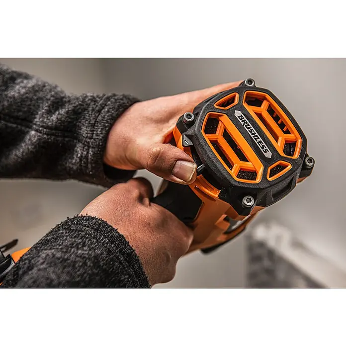 AEG Pro 18V Akku-Nagler B18BN16-0 - 18 V, Ohne Akku, Länge Nagel: 25 mm - 65 mm - Nahaufnahme von Händen, die ein orange-schwarzes bürstenloses Elektrowerkzeug halten.