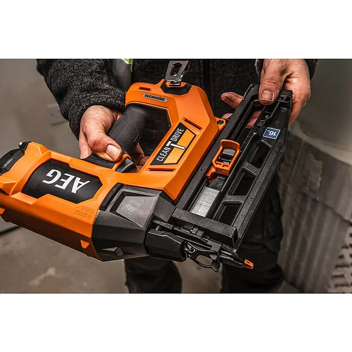 AEG Pro 18V Akku-Nagler B18BN16-0 - 18 V, Ohne Akku, Länge Nagel: 25 mm - 65 mm - Person hält ein oranges und schwarzes AEG 16-Gauge Akku-Finish-Nagelgerät, mit Nägeln beladen.