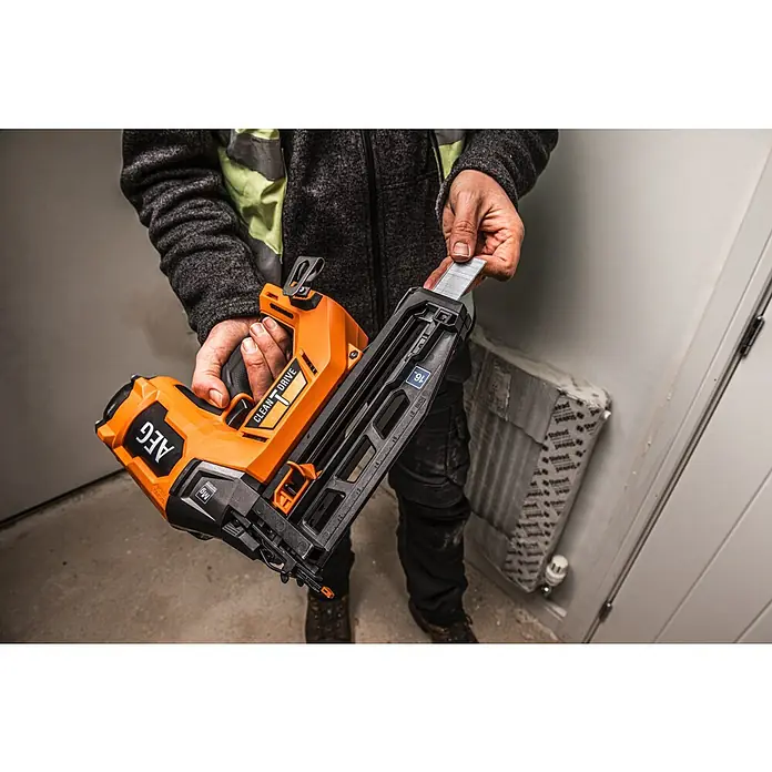 AEG Pro 18V Akku-Nagler B18BN16-0 - 18 V, Ohne Akku, Länge Nagel: 25 mm - 65 mm - Eine Person hält eine orange-schwarze AEG Nagelpistole und lädt Nägel in das Magazin.