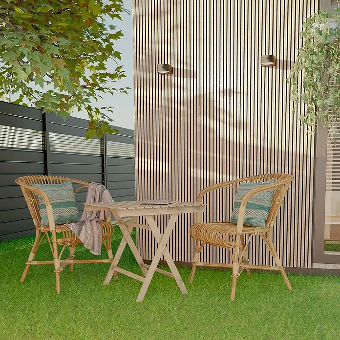 Dioco Revestimiento decorativo alistonado Minus - 220 x 12 cm, Cedar - Juego de muebles de jardín con dos sillas de ratán y una mesa de madera sobre césped verde contra una pared de madera. Perfecto para relajarse al aire libre.