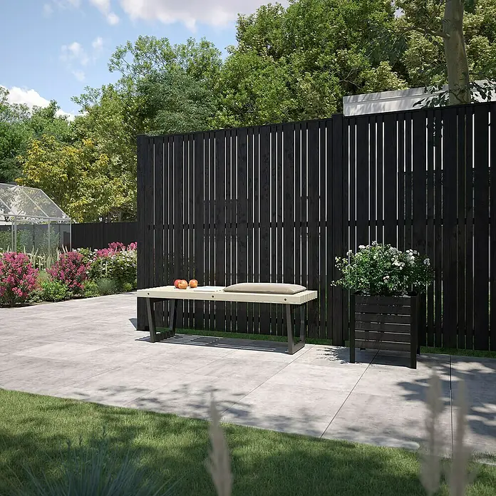 Plus Sichtschutzelement Tangent - 180 x 180 cm, Schwarz (RAL 9005) - Eine moderne Gartenbank mit hellen Holzelementen und dunklen Metallbeinen, die vor einem schwarzen Zaun und einem Blumenkasten steht.
