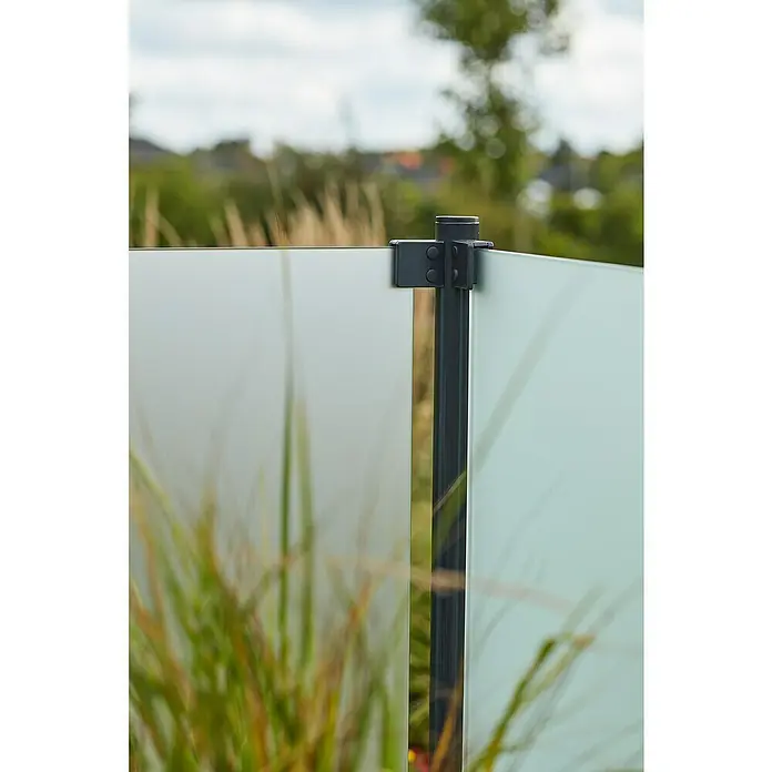 Plus Sichtschutzzaun für runde Pfosten - 90 x 91 cm, Matt satiniert, 6 mm - Nahaufnahme einer Glaszaunkonstruktion mit Metallelementen vor einem verschwommenen Hintergrund.