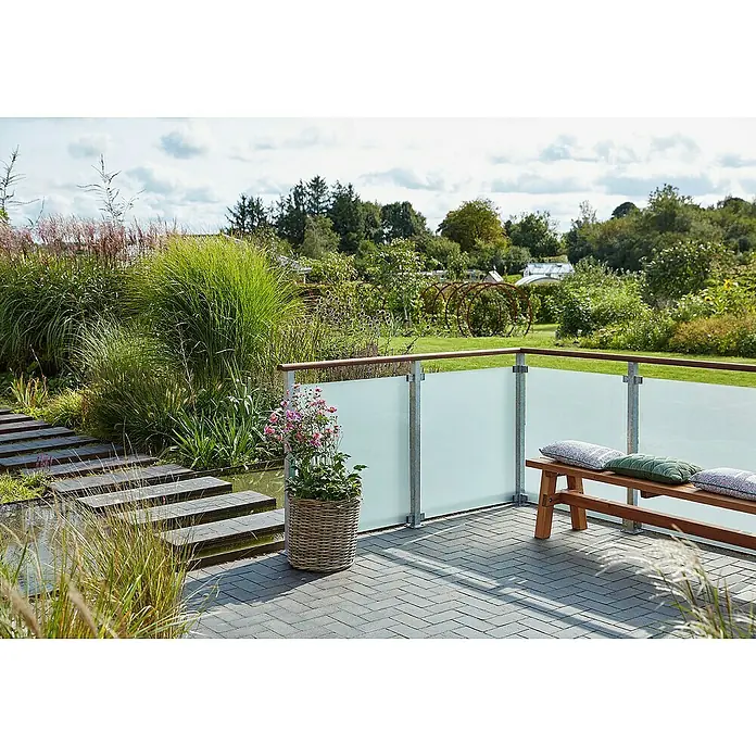 Plus Sichtschutzzaun für quadratische Pfosten - 90 x 91 cm, Matt satiniert, 8,7 mm - Eine Terrasse mit einer Glasbalustrade, einer Holzbank mit Kissen und einem Korb mit rosa Blumen, die eine entspannende Außenumgebung schaffen.