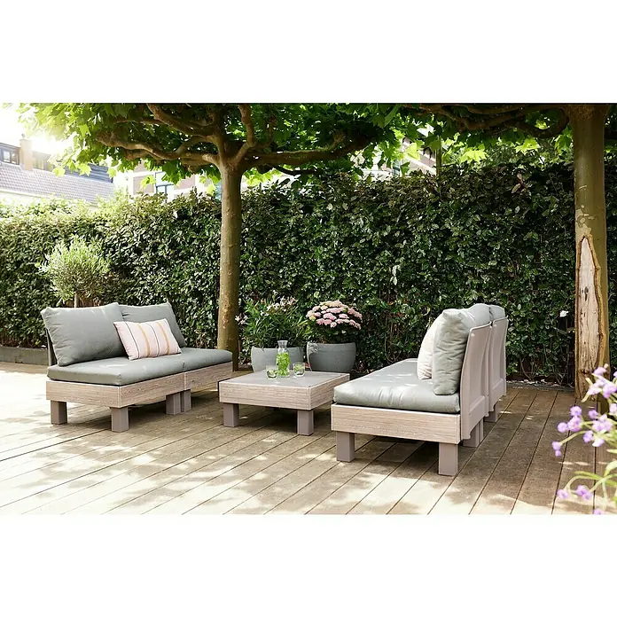 Keter Elements Respaldo de respaldo con cojín - L x An x Al: 60 x 17 x 57 cm, Madera/Verde - Atractivo conjunto de muebles de exterior en una terraza de madera con exuberante vegetación al fondo.